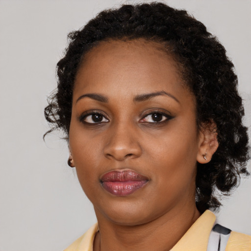 Joyful black young-adult female with medium  black hair and brown eyes