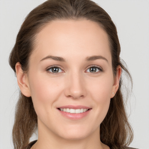 Joyful white young-adult female with medium  brown hair and grey eyes