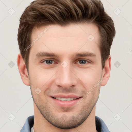 Joyful white young-adult male with short  brown hair and grey eyes