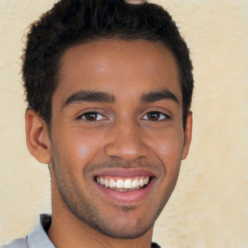 Joyful latino young-adult male with short  brown hair and brown eyes