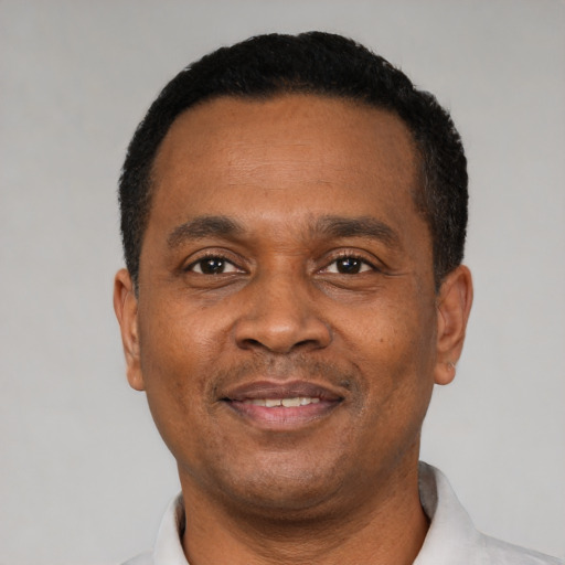 Joyful black adult male with short  black hair and brown eyes