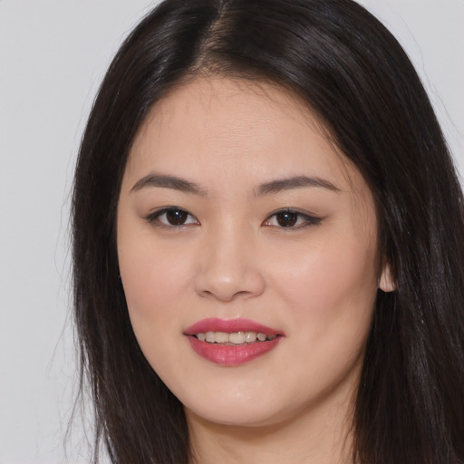 Joyful asian young-adult female with long  brown hair and brown eyes