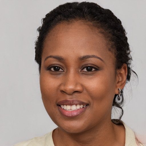 Joyful black young-adult female with short  black hair and brown eyes
