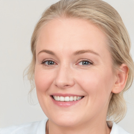 Joyful white young-adult female with medium  brown hair and blue eyes