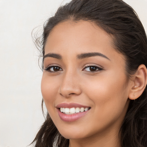 Joyful white young-adult female with long  brown hair and brown eyes