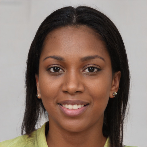 Joyful black young-adult female with long  brown hair and brown eyes