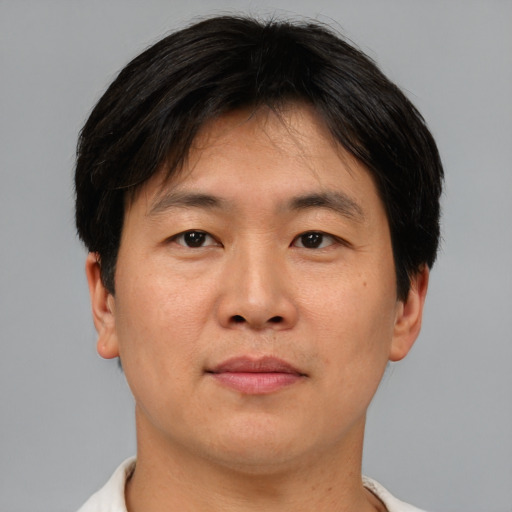 Joyful asian adult male with short  brown hair and brown eyes