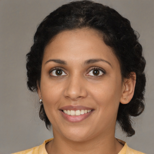 Joyful latino young-adult female with medium  brown hair and brown eyes