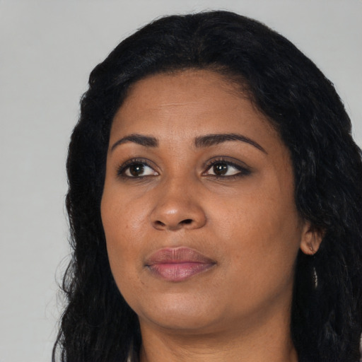 Joyful black young-adult female with long  black hair and brown eyes