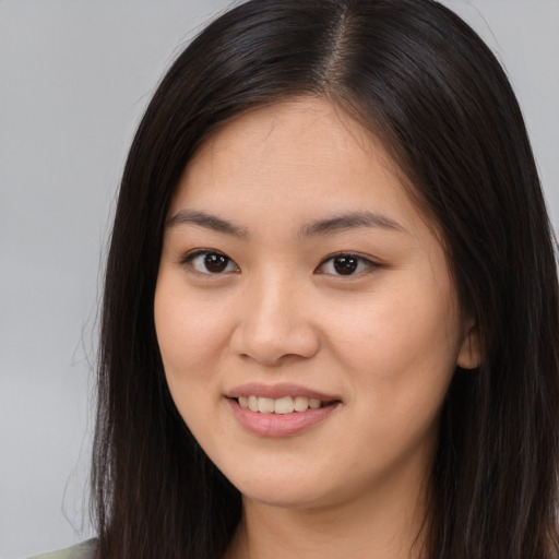 Joyful asian young-adult female with long  brown hair and brown eyes