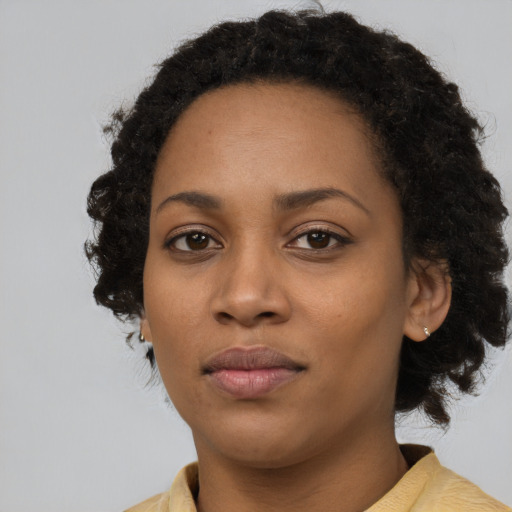 Joyful black young-adult female with medium  brown hair and brown eyes