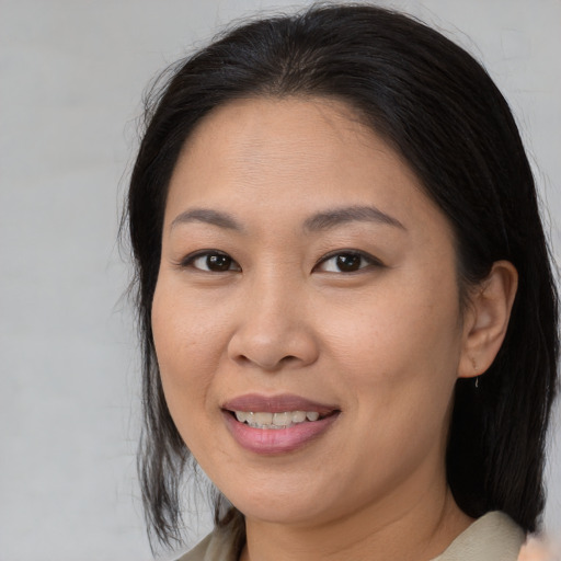 Joyful asian adult female with medium  brown hair and brown eyes