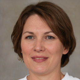 Joyful white adult female with medium  brown hair and grey eyes