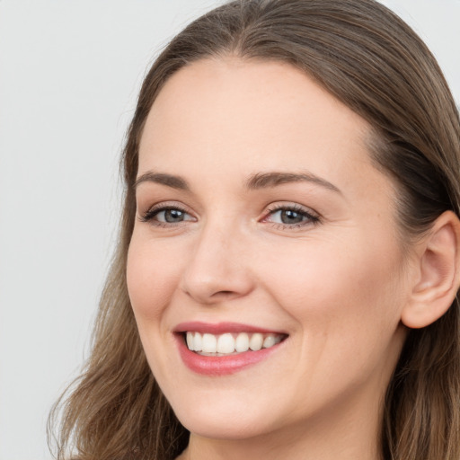 Joyful white young-adult female with long  brown hair and grey eyes