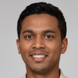 Joyful latino young-adult male with short  black hair and brown eyes