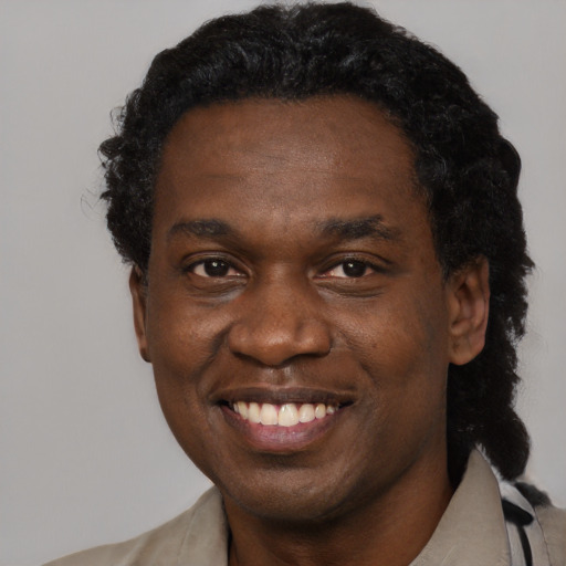 Joyful black young-adult male with short  black hair and brown eyes
