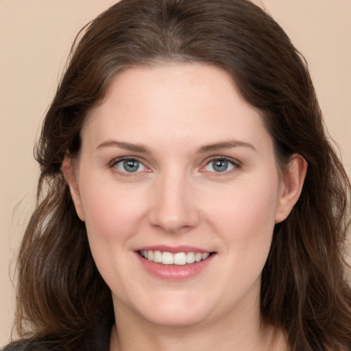 Joyful white young-adult female with long  brown hair and grey eyes