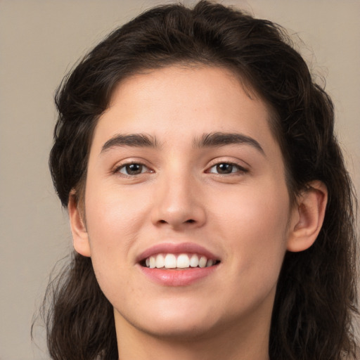 Joyful white young-adult female with long  brown hair and brown eyes