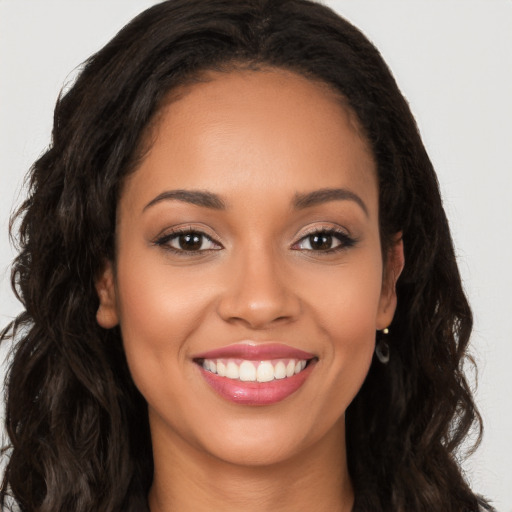 Joyful latino young-adult female with long  brown hair and brown eyes