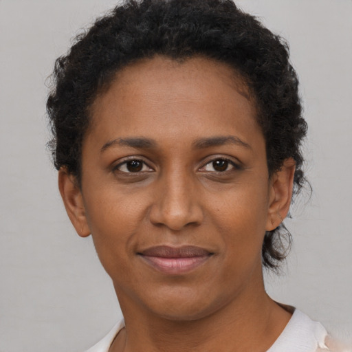 Joyful black young-adult female with short  brown hair and brown eyes