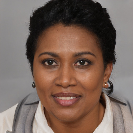 Joyful black adult female with short  brown hair and brown eyes