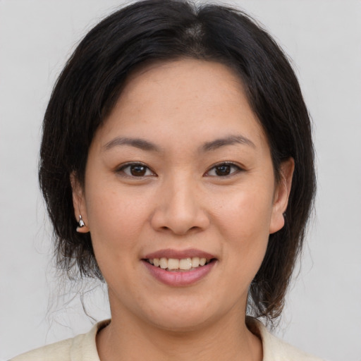 Joyful asian young-adult female with medium  brown hair and brown eyes