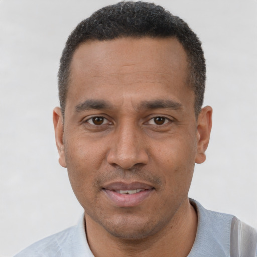 Joyful black adult male with short  brown hair and brown eyes