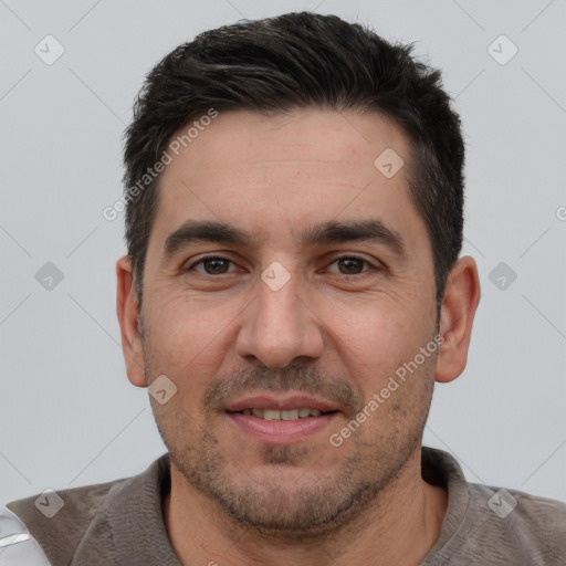 Joyful white adult male with short  black hair and brown eyes