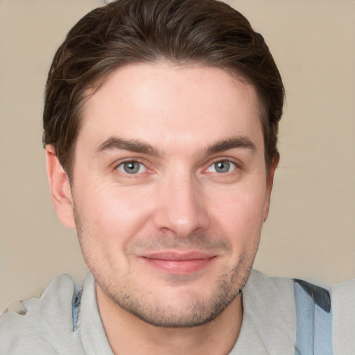 Joyful white young-adult male with short  brown hair and grey eyes