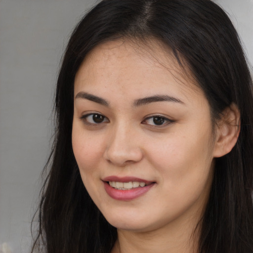 Joyful asian young-adult female with long  brown hair and brown eyes