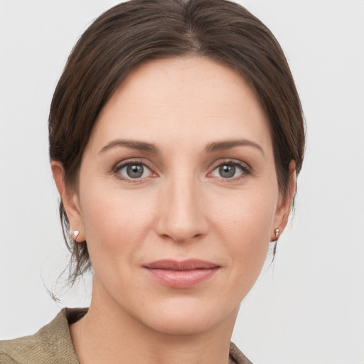 Joyful white young-adult female with short  brown hair and grey eyes