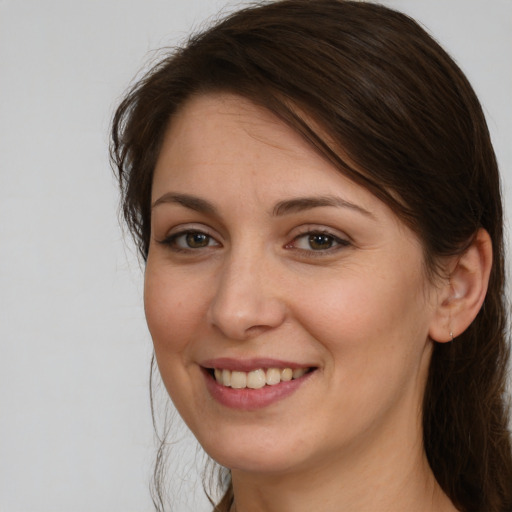 Joyful white young-adult female with long  brown hair and brown eyes