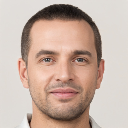 Joyful white young-adult male with short  brown hair and brown eyes