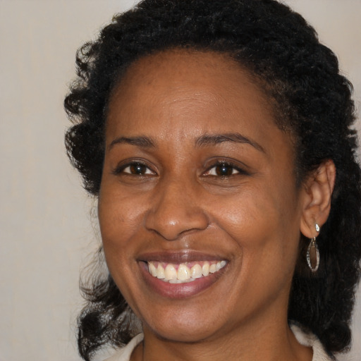 Joyful black adult female with medium  brown hair and brown eyes