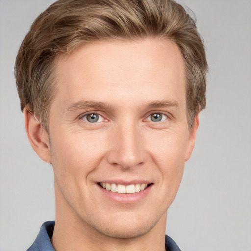 Joyful white young-adult male with short  brown hair and grey eyes