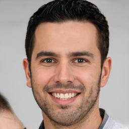 Joyful white young-adult male with short  brown hair and brown eyes