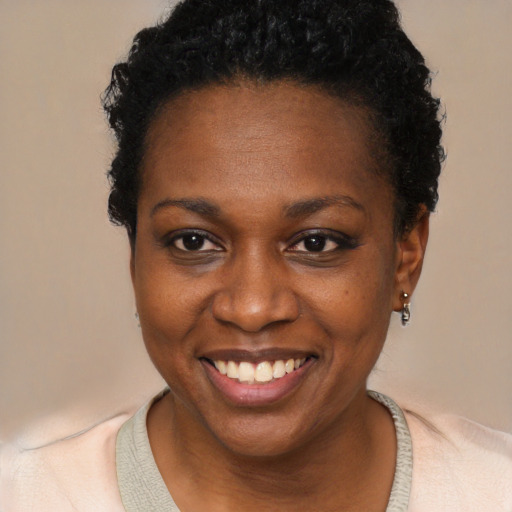 Joyful black young-adult female with short  black hair and brown eyes