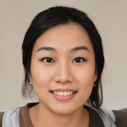 Joyful asian young-adult female with medium  black hair and brown eyes