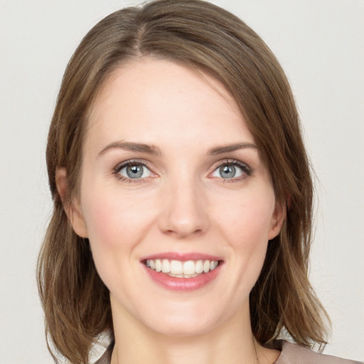 Joyful white young-adult female with medium  brown hair and green eyes