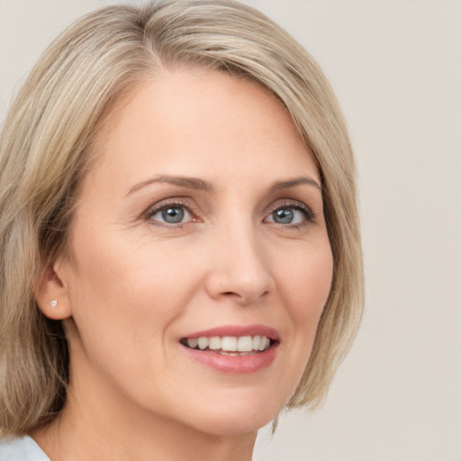 Joyful white young-adult female with medium  blond hair and green eyes