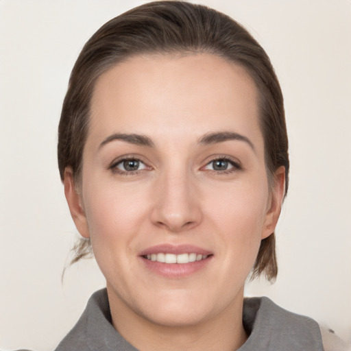 Joyful white young-adult female with medium  brown hair and grey eyes