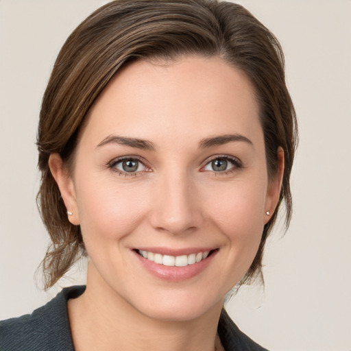 Joyful white young-adult female with medium  brown hair and grey eyes