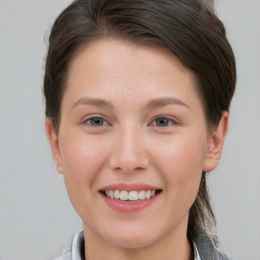 Joyful white young-adult female with short  brown hair and grey eyes