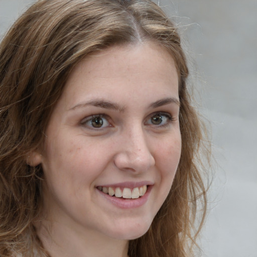 Joyful white young-adult female with long  brown hair and grey eyes