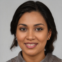 Joyful latino young-adult female with medium  brown hair and brown eyes