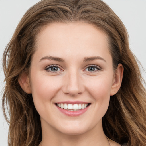 Joyful white young-adult female with long  brown hair and grey eyes