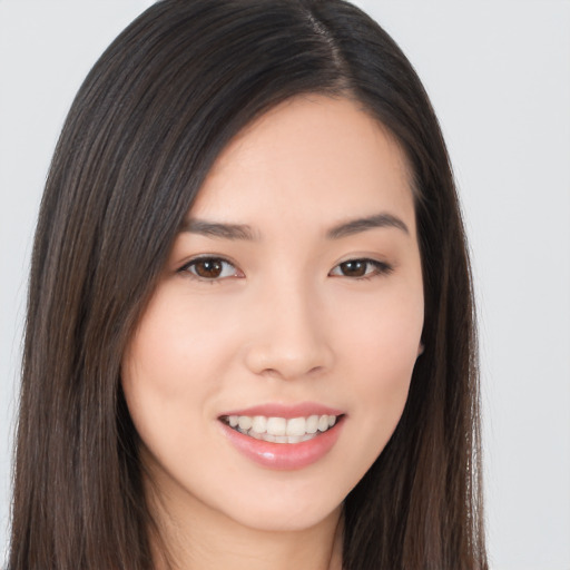 Joyful asian young-adult female with long  brown hair and brown eyes