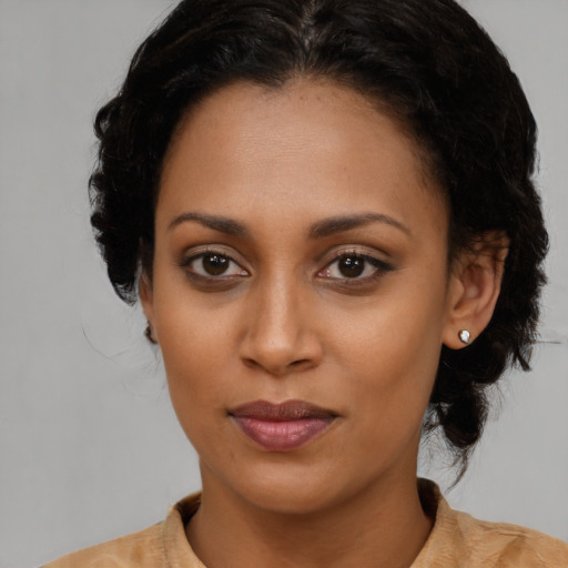 Joyful black young-adult female with medium  brown hair and brown eyes