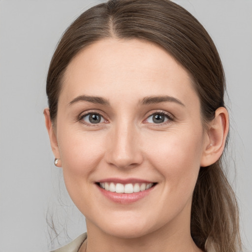 Joyful white young-adult female with long  brown hair and grey eyes