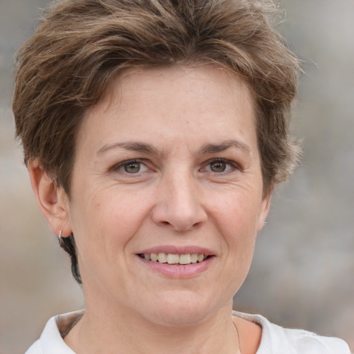 Joyful white adult female with short  brown hair and grey eyes